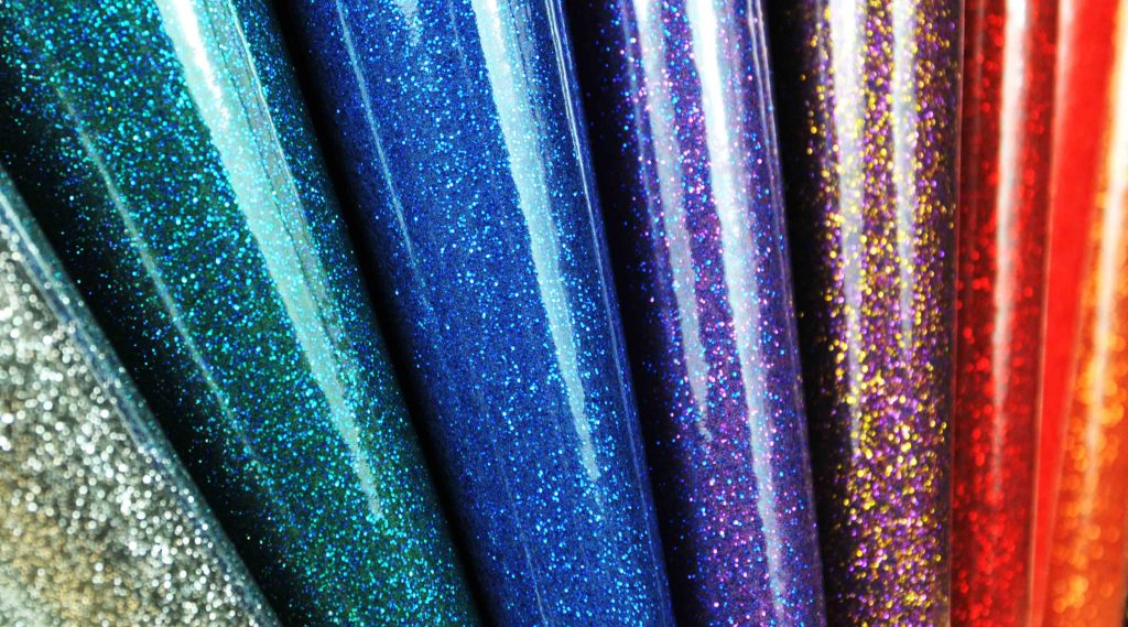 rolls of blue teal silver red gold and purple  thick glitter gloss vinyl leatherette for cars cafe upholstery Christmas decoration craft seating and props